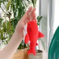 Dettaglio del portachiavi a squalo in peluche rosso con anello in metallo e ricami - 13cm / Catena Pendente / Rosso