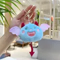 Détail d'un porte-clés monstre en peluche avec ailes pailletées tenu dans la main - Fermoir Doré / Bleu