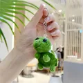 Detailopname van de groene pluche schildpad sleutelhanger met zachte stof en metalen ring - Metalen ball chain / Donkergroen