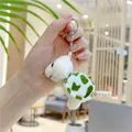 Detailopname van een pluche groene schildpad sleutelhanger vastgehouden in hand - Metalen ball chain / Beige