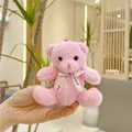 Detailaufnahme eines rosa Teddybär-Schlüsselanhängers mit Love-Schleife auf einer Hand - Einfache Kette / Rosa