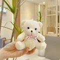 Nahaufnahme eines cremefarbenen Teddybären-Schlüsselanhängers mit rosa Love-Schleife - Einfache Kette / Gebrochenes Weiß