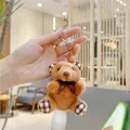 Detail eines braunen Teddybär-Schlüsselanhängers mit klassischen Karo-Akzenten an Ohren - Hängeketten-Stil / Dunkelbraun