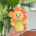 Close-up of yellow plush duck keychain with flower collar in front of green leaves - Orange Sunflower Style