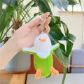 Dettaglio del portachiavi a forma di anatra banana in peluche con sfondo di piante verdi - Verde Con Fermaglio Dorato