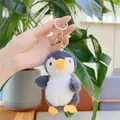 Detailed view of a soft grey penguin plush keychain being held to show its 10cm size - Gold Clasp / Gray