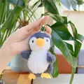 Close-up of fluffy penguin plush keychain held in hand showing soft long-hair texture - Hanging Chain / Gray