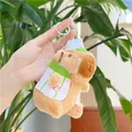 Detalle de un llavero de peluche de capibara con uniforme de béisbol y una letra C rosa - Usando Ropa (Cadena) / Tostado