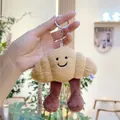 Cute croissant plush keychain with smiley face and long legs held by hand - Plain Chain