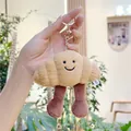 Detail of plush croissant keychain with smiley face embroidery and gold clasp - Gold Clasp