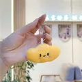 Gros plan d'un porte-clés en peluche nuage jaune avec un visage souriant et une chaîne argentée - Petit Lingot avec Chaîne à Billes Argentée
