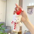 Close-up of white plush bear keychain with red Christmas hat and striped scarf - Gold Lobster Clasp / Off-White Red White Scarf