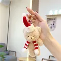 Detail view of a plush Christmas bear keychain with red hat and striped scarf - Gold Lobster Clasp / Brown Red White Scarf