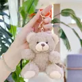 Close-up of a curly plush teddy bear keychain with a gold metal ring for bags - Gold Clasp / Dark Brown White Mouth / 11cm