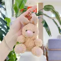Cute brown plush bunny keychain with golden ring held against a cozy indoor plant background - Gold Clasp / Light Brown Rabbit / 11cm