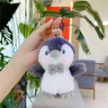 Detailansicht eines weichen grauen Pinguin-Plüschanhängers mit blauen Augen und Schleife - Hängeketten-Stil / Grau