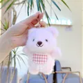 Detailed shot of pink plush bear keychain featuring a red checkered bib and lace trim - Hanging Chain / Pink