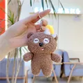 Close-up of brown plush teddy bear keychain with curly faux lamb wool and metal ring - Chain Style / Yellow Hat / Approx. 11cm