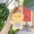 Macro detail of a yellow plush chick charm with a lace apron and star accessory - Yellow Chick / Plain Chain