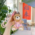 Détail du porte-clés ours en peluche avec salopette en velours rose et mini caméra - Style Salopette Rose