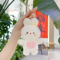 Close-up of white plush bunny keychain with pink plaid bib and golden metal clasp - White Rabbit / Gold Metal Buckle