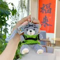 Makro-Detail von süßem Teddybär-Plüschanhänger mit Strickpullover und Schutzbrille - Grauer Bär - Grün Gestreifter Pullover (Schutzbrille Stil)