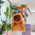 Close-up of plush Capybara keychain with a green bow being held in hand - Plain Chain / Green Bow
