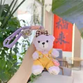 Pendentif ours en peluche violet avec salopette en velours jaune et dragonne - Style Salopette Jaune