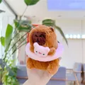 Macro view of plush Capybara keychain with pink swim ring and soft brown fur texture - Pink
