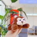 Gros plan d'un petit singe en peluche porte-clés avec une fourrure douce marron et beige - Style de Chaîne / Marron