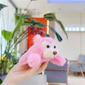 Détail d'un pendentif singe en peluche rose pêche avec texture douce en main - Style de Chaîne / Rose