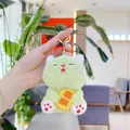 Close-up of green plush cat keychain holding a yellow tag with embroidery detail - Green With Gold Clasp