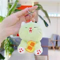Detail of light green plush cat keychain with embroidery and Joy charm held in hand - Green With Chain