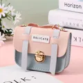 Detailed close-up of pink and blue mini purse with delicate label and gold lock - Blue