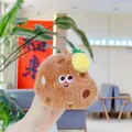 Plush brown food keychain with embroidered face and pineapple detail held in hand - Cookie (Chain)