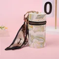 Dettaglio del ricamo floreale su astuccio per rossetto in pelle con foulard di seta - Verde (A222)