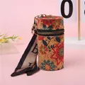Detalle del mini bolso cilíndrico de corcho con estampado floral y cinta de seda - Veta de Madera Floral