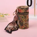 Detalle de mini bolso cilíndrico vintage con estampado abstracto y cinta dorada con letra B - Veta de Madera Círculos