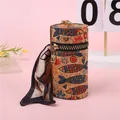 Detalle del neceser cilíndrico de corcho con estampados de peces y bufanda de seda - Veta de Madera Pez