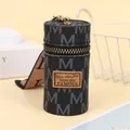 Macro view of vintage monogram mini bucket pouch with gold zipper and silk strap - Black