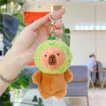 Close-up of plush capybara keychain wearing a green avocado hat with soft brown fur - Lime/Frog Style (Green with Golden Buckle)