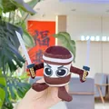 Close-up of a plush warrior doll pendant holding two swords with cartoon eyes - Brown Ninja Small (Gold Clasp)