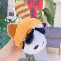 Detail eines flauschigen Panda-Anhängers mit orange gestreiftem Schwanz und Fell - Wende-Panda Hängende Kette