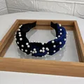 Navy blue velvet knotted headband with white pearls on a minimalist wooden frame background - Navy Blue
