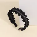 Detailed close-up of a pleated black headband featuring sparkling crystals and a toothed inner grip - Pleated Style / Black