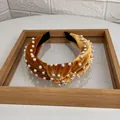 Golden brown velvet knotted headband with white pearls for a retro fashion look - Turmeric