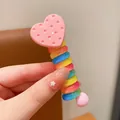 Detail of colorful rainbow spiral hair tie with a pink heart pendant and dotted texture - Heart Shape