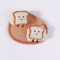 Detailaufnahme süßer Plüsch-Toast-Armbänder zum Gesichtwaschen auf einem Holztablett - Beiger Toast-Stil