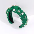 Green fabric knotted headband with baroque pearls and rhinestones on a white stand - Green
