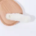 Eleganter weißer Kunstpelz-Haarclip mit Perle auf einem Holztablett serviert - Weiß